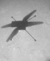 Autor: NASA/JPL-Caltech - Stín helikoptéry Ingenuity pořízený navigační kamerou během jejího 19. letu na povrchu Marsu (na Zemi 8. února 2022, na Marsu 345. den od přistání Perseverance). Poblíž stínu je vidět i slabé sopy kol Perseverance, která tudy projela několik měsíců nazpět. Vrtulník se vrací do místa přistání roveru.