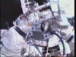 Záběr z kamery na helmě Olega; Dmitrij pracuje s předměty v přechodové komoře. Autor: TV NASA