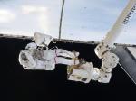 Steve Bowen pracuje připevněný k robotické paži. Autor: NASA
