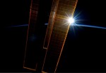 Slunce vycházející za solárními panely ISS. Credit: NASA/ESA