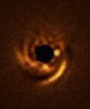 Autor: ESO/F. Maio et al. - Tento snímek pořízený pomocí dalekohledu ESO VLT ukazuje spirální disk kolem mladé hvězdy HD 135344B. Snímek byl pořízen přístrojem ERIS na VLT, který nalezl kandidáta na planetu, která může být součástí spirálního disku. Poloha této planety je vyznačena bílým kroužkem.