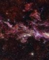 Autor: ALMA(ESO/NAOJ/NRAO)/S. Longmore et al. Background: ESO/D. Minniti et al. - Tento snímek ukazuje složité rozložení molekulárního plynu v centrální molekulární zóně (CMZ) Mléčné dráhy. Byl pořízen pomocí observatoře ALMA, jehož partnerem je ESO. Tato mapa je součástí projektu ACES, jehož cílem je pochopit, jak se plyn kondenzuje do hvězd v extrémním a chaotickém prostředí v jádru naší galaxie. Průzkum zmapoval rozložení desítek různých molekul, z nichž pět je zde zobrazeno v různých barvách: oxid siřičitý (azurová), oxid křemičitý (zelená), kyselina isokyanová (červená), kyanacetylen (modrá) a monosulfid uhlíku (magenta).