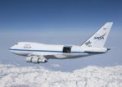 Autor: NASA/Jim Ross - SOFIA letící nad sněhem pokrytým pohořím Sierra Nevada s otevřeným krytem dalekohledu během zkušebního letu; jedná se o upravený letoun Boeing 747SP