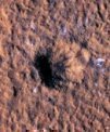Autor: NASA/JPL-Caltech/University of Arizona - Kolem okraje kráteru na Marsu vidíme bloky ledu velké jako menší skály nebo větší balvany. Zachytila jej kamera HiRISE sondy MRO (Mars Reconnaissance Orbiter). Kráter vznikl 24. 12. 2021 dopadem meteoroidu do oblasti Amazonis Planitia.