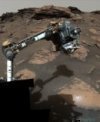 Autor: NASA/JPL - Rover Perseverance pracující na skalnatém výběžku zvaném Skinner Ridge v kráteru Jezero na Marsu. Na konci paže se nachází přístroj SHERLOC s Ramanovým UV spektrometrem, který objevil organickou hmotu. Zdroj: NASA/JPL-Caltech/ASU/MSSS