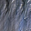 Autor: NASA/JPL-Caltech/University of Arizona - Rokle vytvořené na svahu kráterového valu