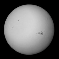 Slunce 9. 5. 2024 v 10:56 SELČ. Snímek mobilem za okulárem dalekohledu upraveného pro bezpečné pozorování Slunce (Vixen 81S a Herschelův hranol). Skupina skvrn v aktivní oblasti AR13664 je jedna z největších v historii pozorování Slunce. Autor: Martin Gembec