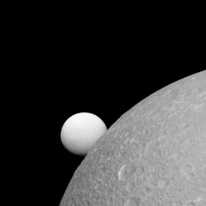 Dione s měsíce Enceladus (v pozadí) Autor: NASA/JPL-Caltech/Space Science Institute