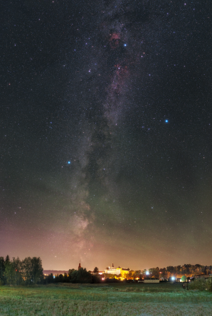 Mléčná dráha a airglow nad Broumovem, v dáli nad obzorem se tyčí Broumovský klášter. Autor: Petr Horálek.