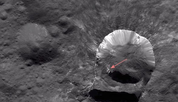 Šipka ukazuje světlou skvrnu v kráteru Oxo, která je zřejmě původcem detekce vody přímo na povrchu Ceresu Autor: NASA/Dawn