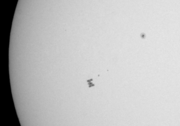 ISS při přeletu před Sluncem spolu se skvrnami na jeho povrchu. 16. 7. 2011, v ohnisku 1200 mm dobsonu o průměru 150 mm. Filtr z fólie Baader AstroSolar Autor: Martin Gembec