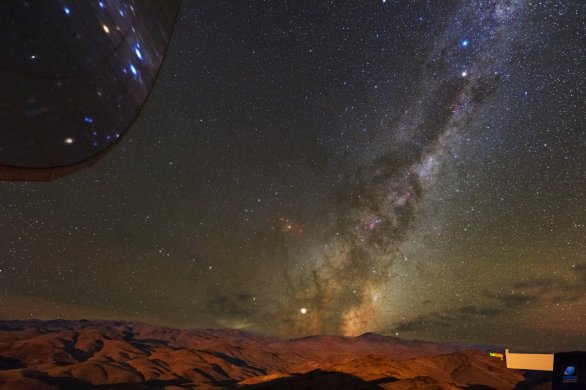 Mléčná dráha nad pouští Atacama ozářená zapadajícím Měsícem. Vlevo nahoře část parabolické antény radioteleskopu SEST. ESO, La Silla, Chile Autor: Zdeněk Bardon