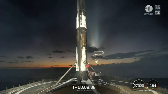 První stupeň rakety Falcon 9 právě dosedl na palubu plošiny A Shortfall Of Gravitas (ASOG) v Atlantiku. V pozadí na obloze je stopa spalin po startu z Floridy. Raketa vynášela telekomunikační družice Intelsat Galaxy 33 a 34 dne 9. 10. 2022