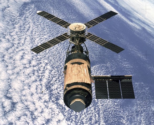 Stanice Skylab na snímku, který 8. února 1974 pořídila posádka poslední lodi Apollo programu Skylab. Pomačkaná „harmonika“ je náhradní štít proti mikrometeoritům a přehřívání stanice, který nainstalovala první posádka během mise Skylab 2 (někdy označované Skylab I). Původní štít byl poškozen a ztracen při startu. Opačnému konci stanice dominuje Sluneční observatoř ATM. Autor: Wikimedia Commons