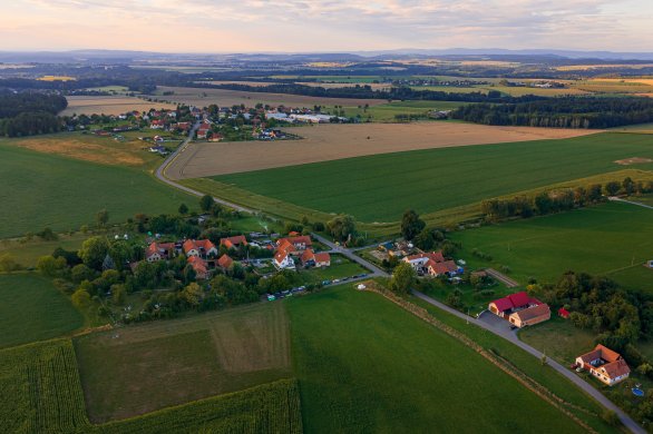 Sítiny - dějiště Astronomické expedice. Vlevo dole se nachází vysekaná obrovská pozorovací louka. Na ohraničeném pozemku jde vidět několik lidí a dalekohledy. Autor: Pavel Karas