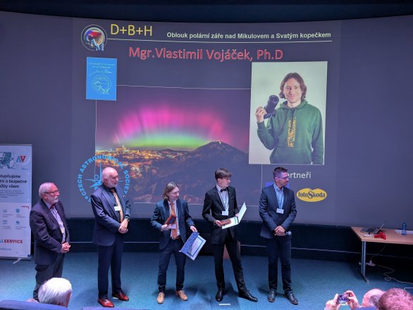 Nositelem Ceny Jindřicha Zemana za astrofotografii roku 2024 je Vlastimil Vojáček (uprostřed) s fotografií Oblouk polární záře nad Mikulovem a Svatým kopečkem 11. 5. 2024. Autor: Martin Gembec