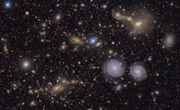 Miliony galaxií na prvním publikovaném snímku Observatoře Vera C. Rubinové. Na obrázku je pouze část obřího zorného pole kamery dalekohledu a vidíme zde modré blízké spirální galaxie i mnoho velmi vzdálených kup galaxií v pozadí. Autor: NSF–DOE Vera C. Rubin Observatory